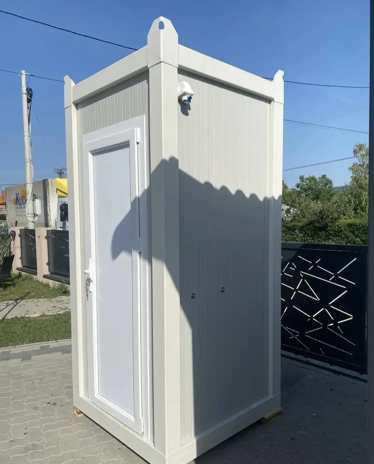 White single-room flush restroom cabin outdoors